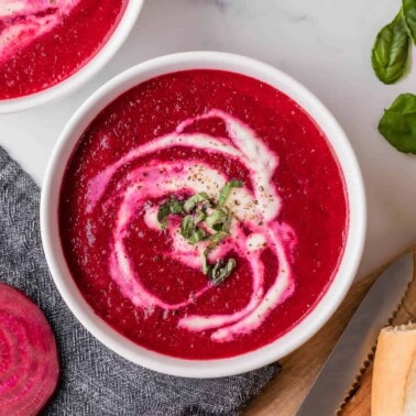 bowl of fresh beet soup garnished with cream.