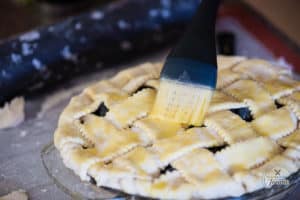 pastry brush adding egg wash to lattice pie crust
