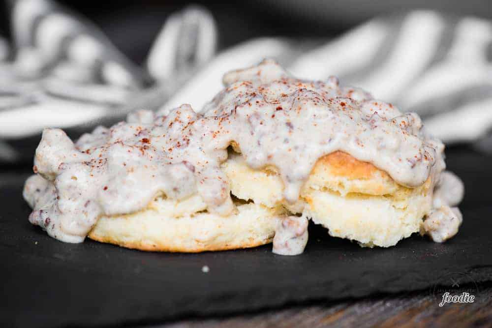 two homemade biscuits topped with gluten free country sausage gravy