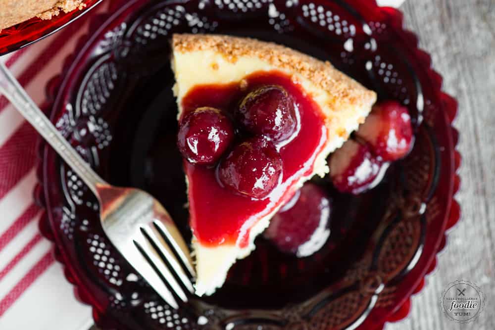 slice of homemade classic cheesecake with cherry topping