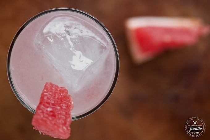 top view of grapefruit cocktail with wedge of fresh grapefruit on glass