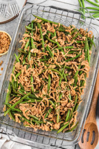 homemade green bean casserole with fried onion pieces in glass casserole dish.