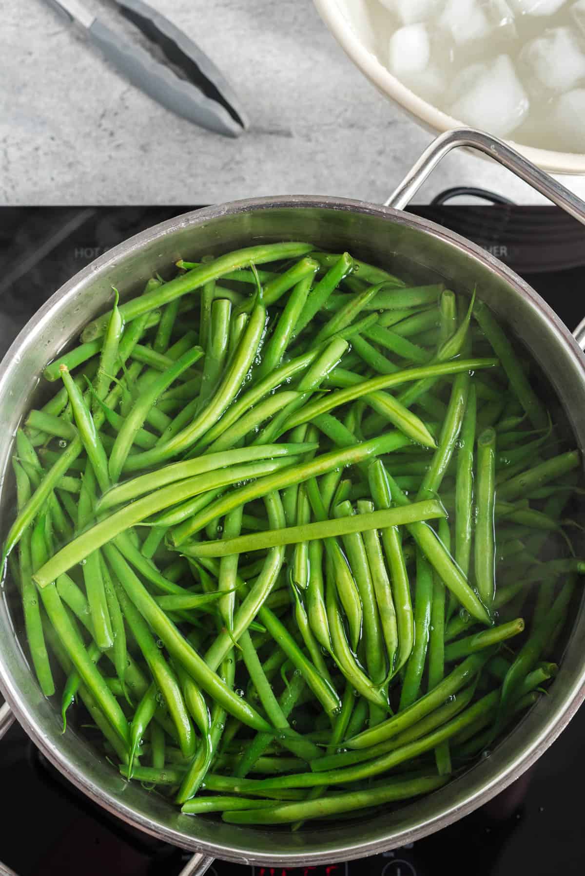 blanching fresh green beans in pot of salted boiling water.