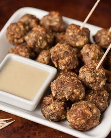 Four ingredient Green Chile Cheddar Meatballs are easy to make, taste fantastic with white cheddar cheese sauce, & can be eaten as a main dish or appetizer.