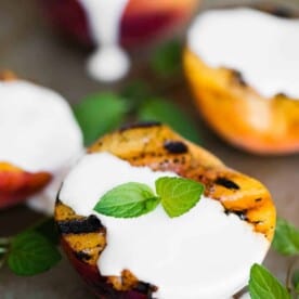 four grilled peach halves with sweet cream