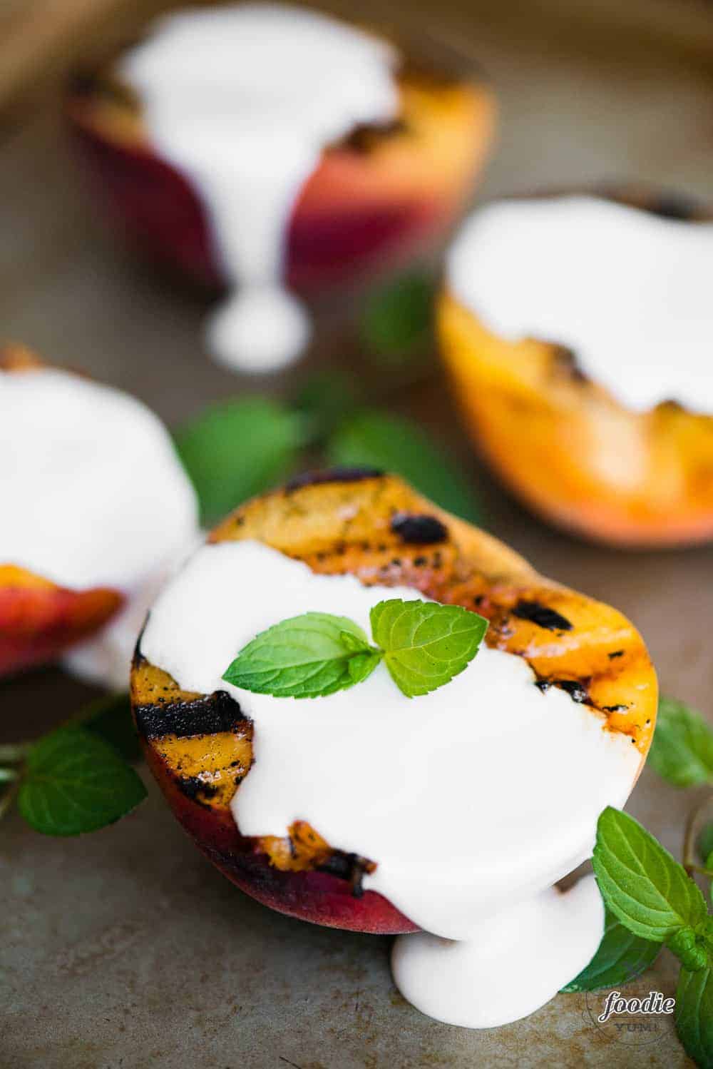 four grilled peach halves with sweet cream