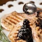 a close up of a grilled pork chop with balsamic butter sauce on top