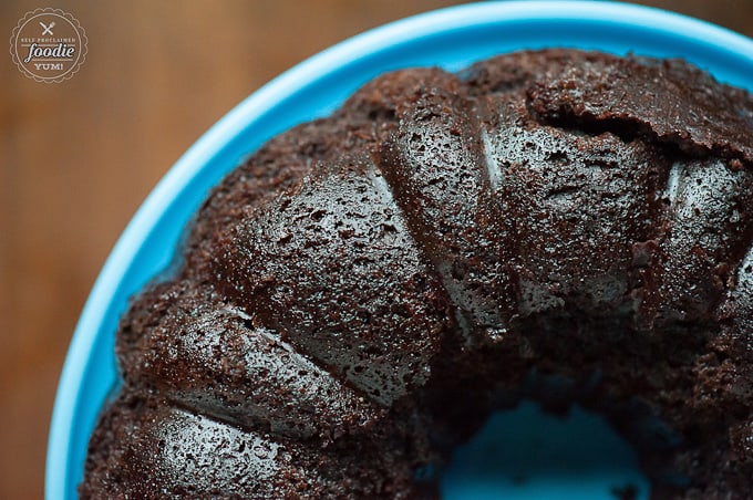 Top of chocolate bundt cake on blue cake dish