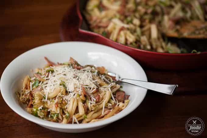 A bowl of  pasta with ham and brussels sprouts