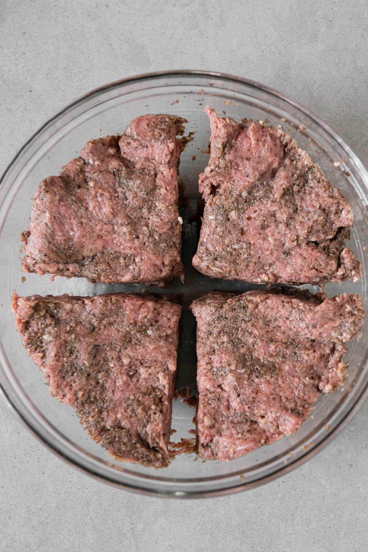ground beef divided into four sections for hamburgers