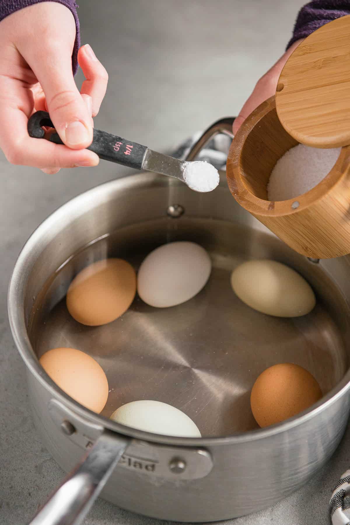 adding salt to pan with water and eggs.
