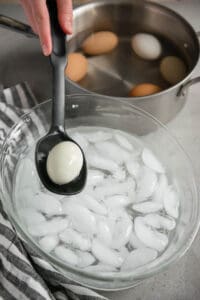 setting hard boiled egg into ice water bath.