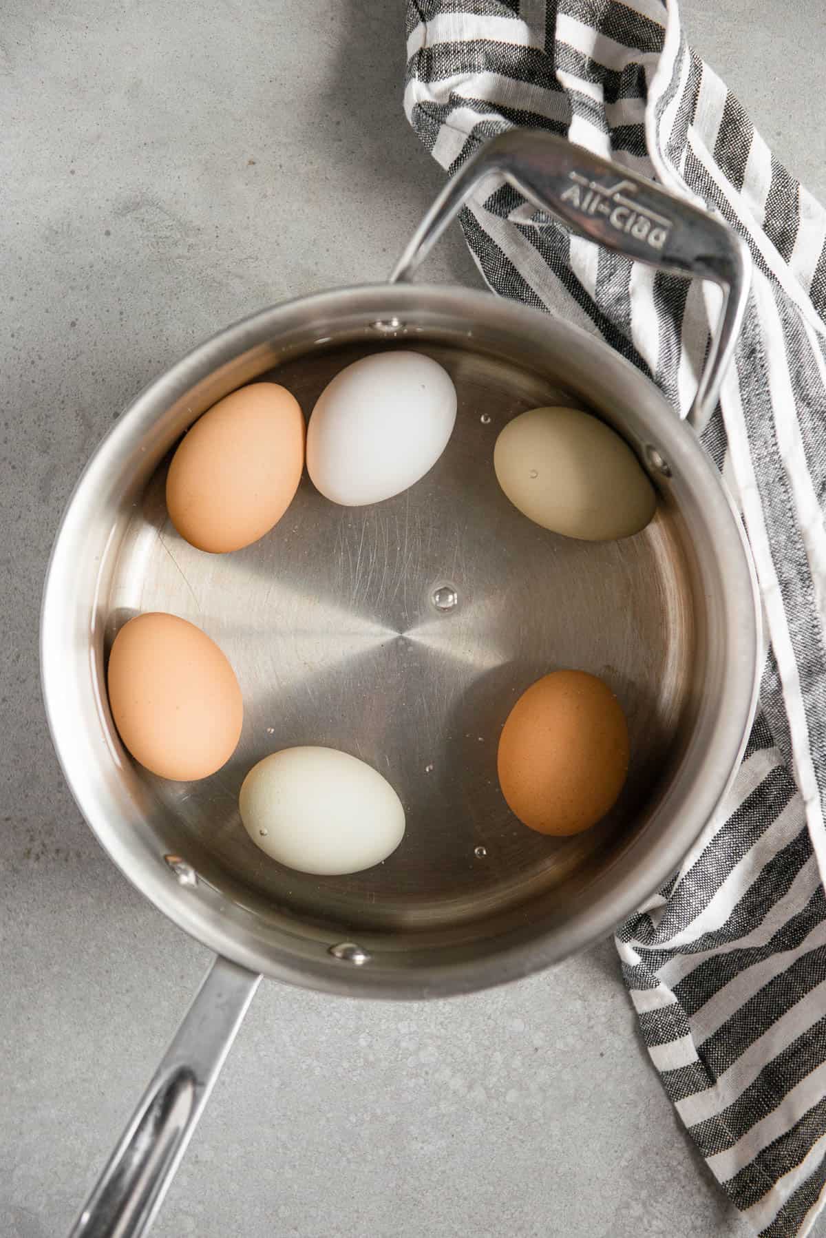 eggs covered in water in pan.