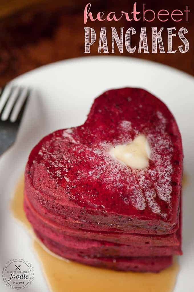 heart shaped red pancakes with butter and syrup