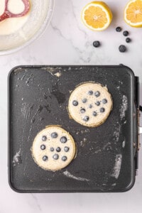 blueberries dotted with a bit of pancake batter on griddle to prevent sticking.