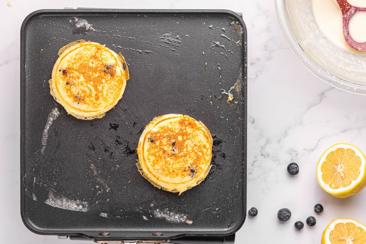 homemade blueberry pancakes on griddle.