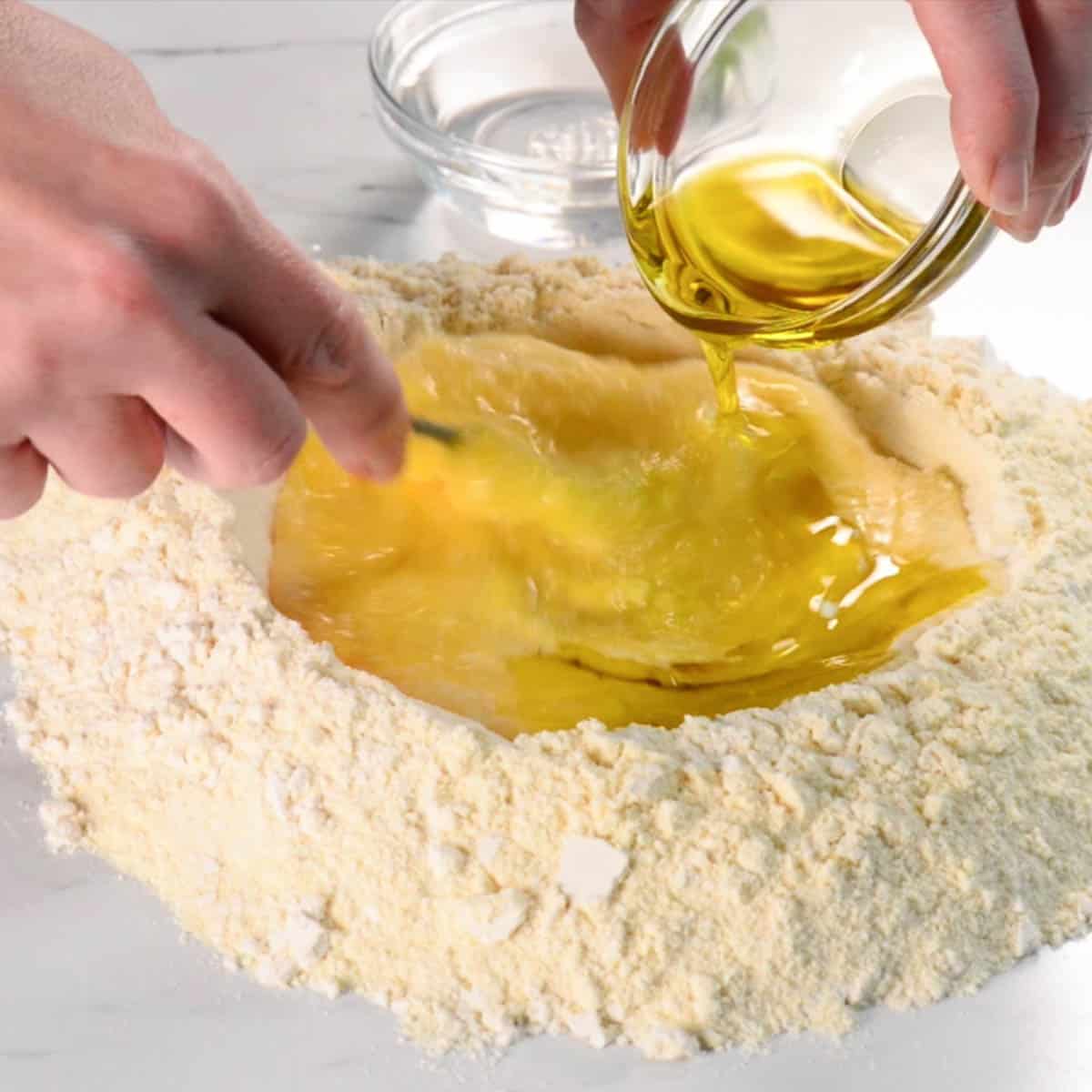 adding oil to homemade pasta dough.