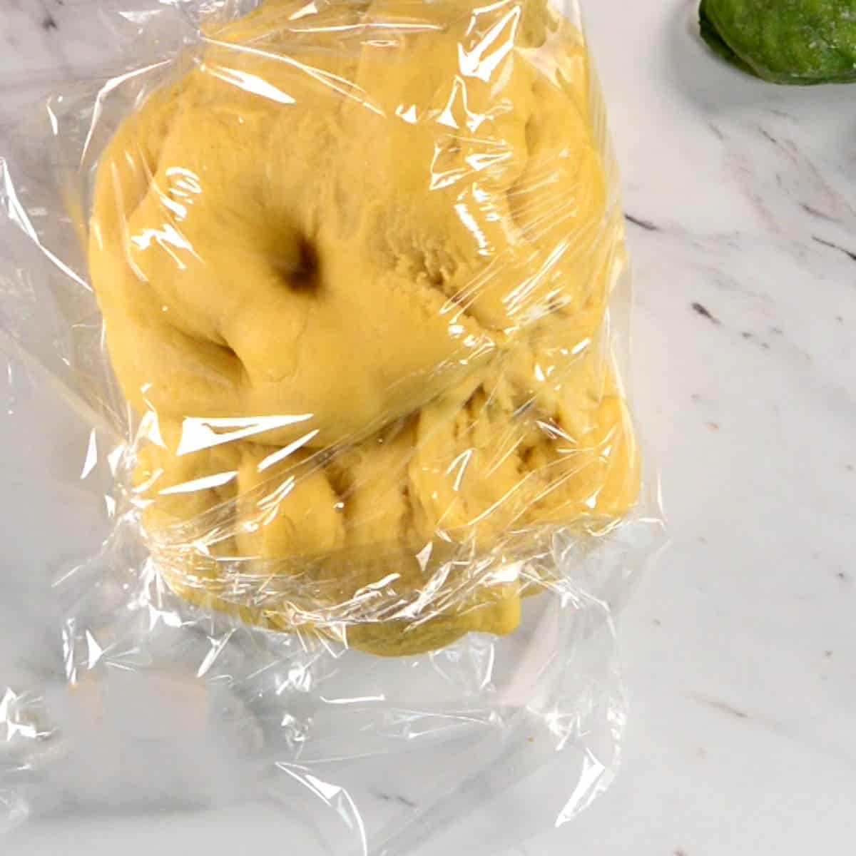 wrapping homemade pasta dough in plastic wrap.