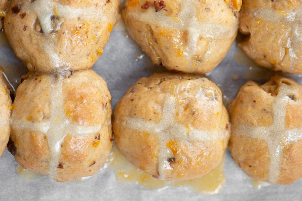 homemade orange glazed hot cross buns with raisins and dried apricots.