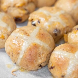homemade orange glazed hot cross buns with raisins and dried apricots.