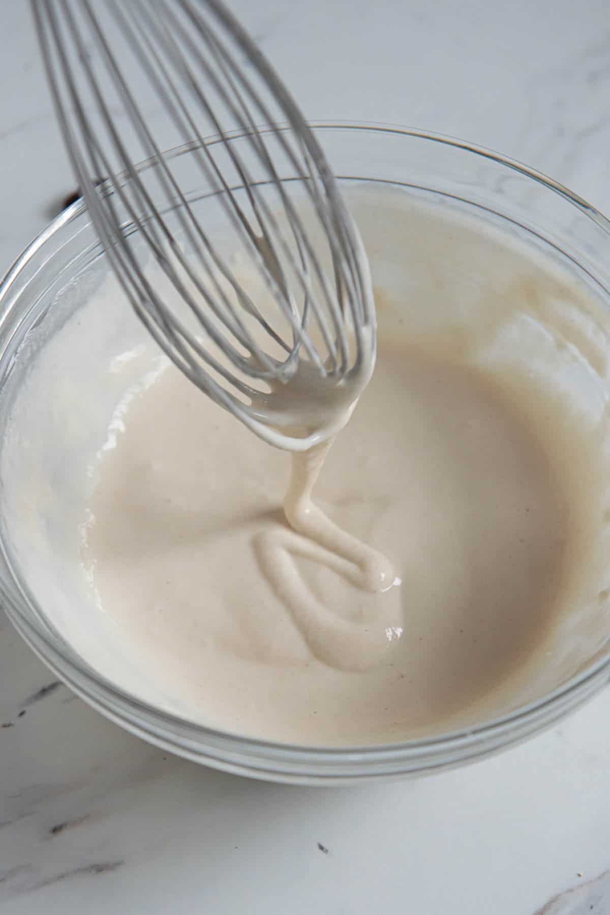 whisking flour and water to make paste for hot cross bun recipe.
