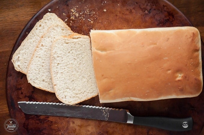 Top of a homemade loaf of bread with three slices