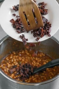 adding cooked crisp bacon to baked beans