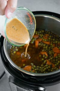 pouring cornstarch slurry into beef stew