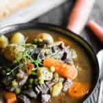 bowl of beef stew with potatoes, carrots and peas