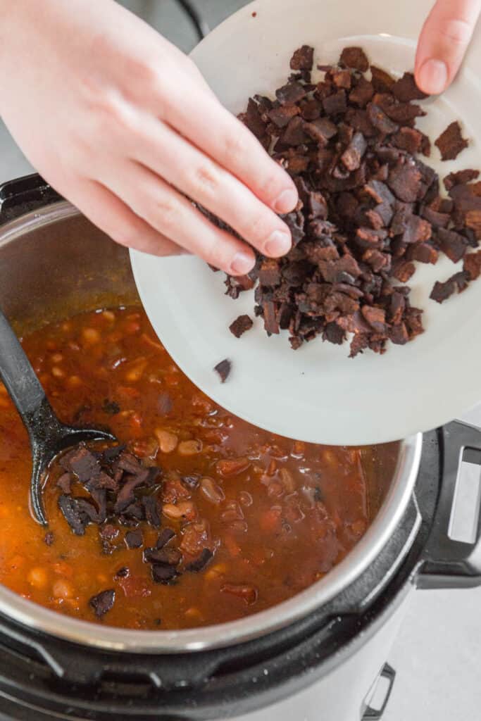 adding crisp cooked bacon to Mexican pinto beans