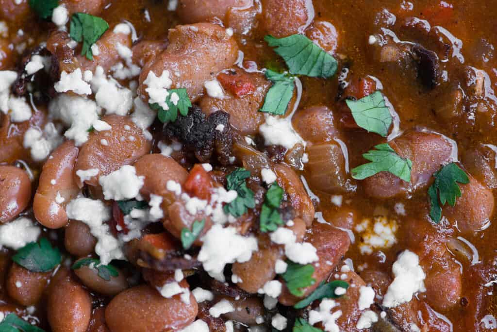close up of charro pinto beans with cotija cheese