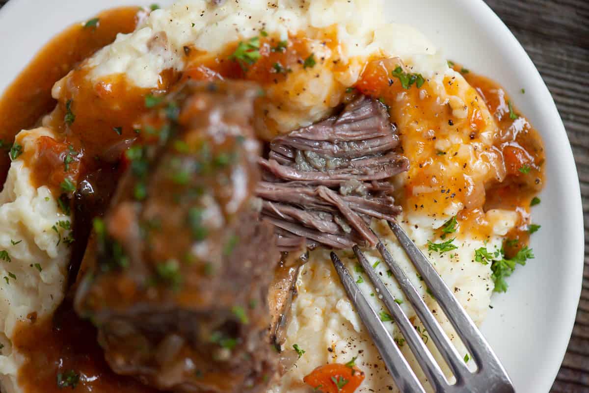 tender instant pot short ribs with gravy over mashed potatoes.