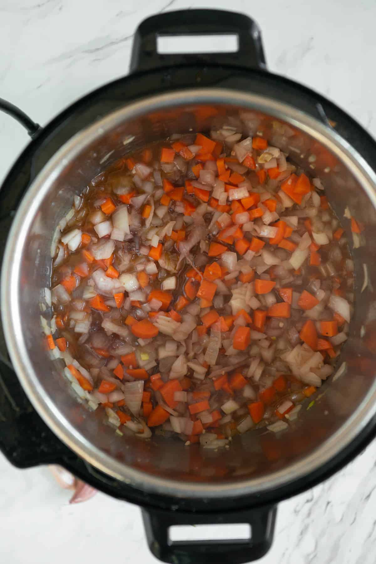 sauteed onions and carrots with wine and beef broth in instant pot.