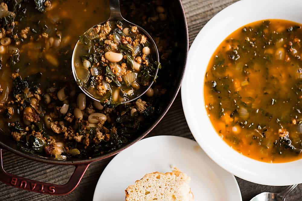 ladle of soup over pot with bowl