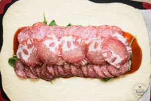 making an Italian stromboli with cured meats
