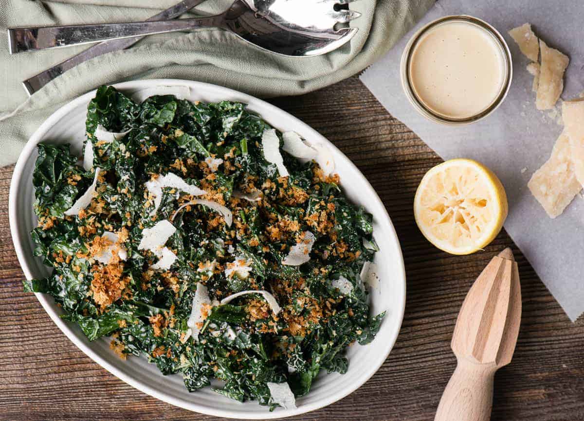 kale ceasar in oval dish with dressing on the side