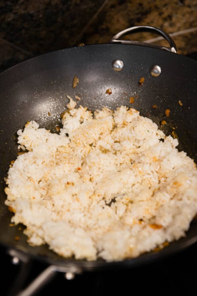 cooking white rice in wok pan for fried rice recipe