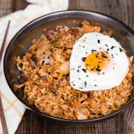 kimchi fried rice with bacon topped with fried egg in bowl