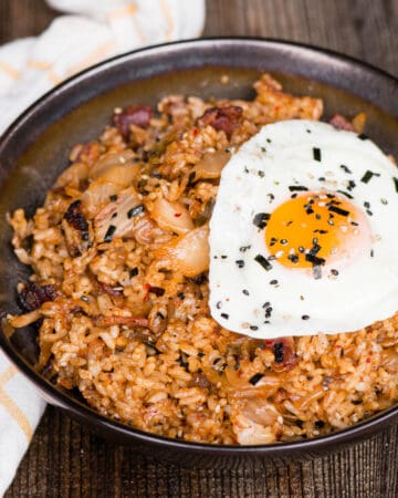 kimchi fried rice with bacon topped with fried egg in bowl