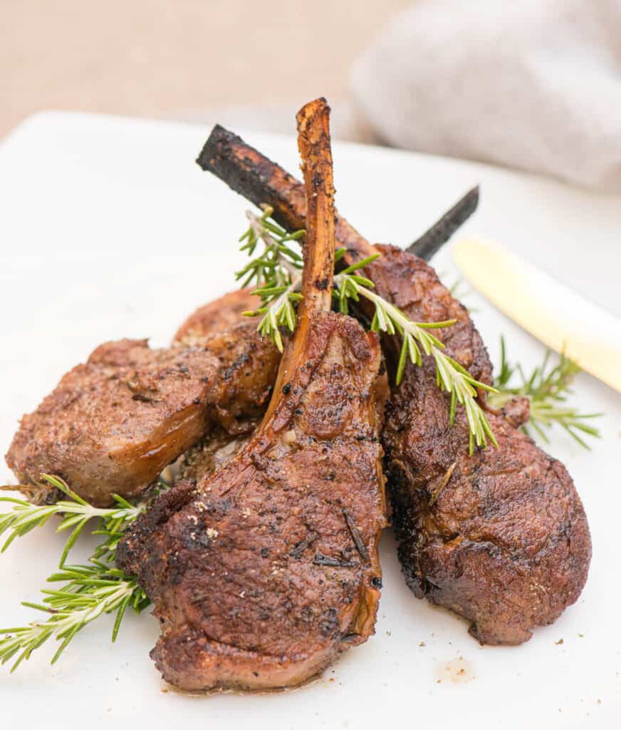 grilled lamb chops on plate with rosemary
