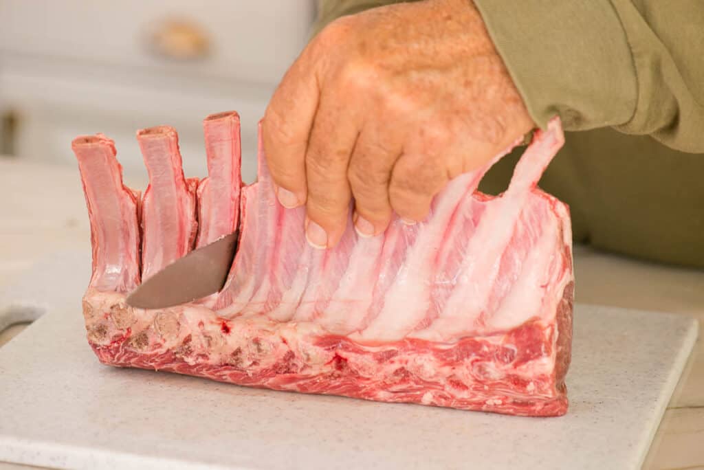 slicing rack of lamb into individual lamb chops