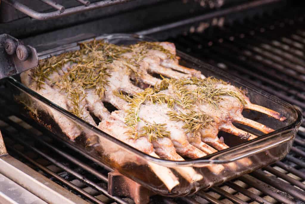 grilling rack of lamb in dish on grill