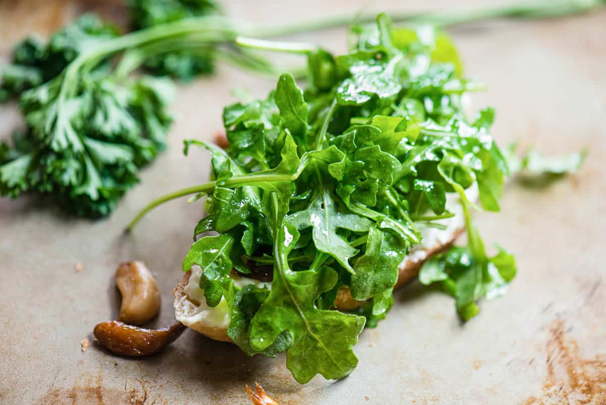 dressed arugula greens on toast for sandwich recipe