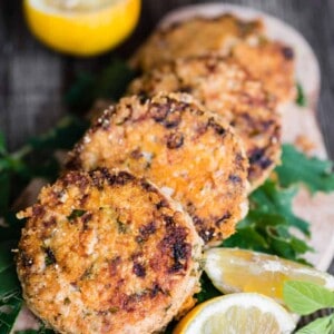 golden brown lemon basil salmon patties with lemon and lemon basil garnish