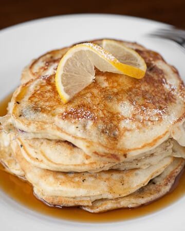 Start your morning off right with the most fluffy and flavorful Lemon Blueberry Buttermilk Pancakes with warm maple syrup for breakfast. YUM!