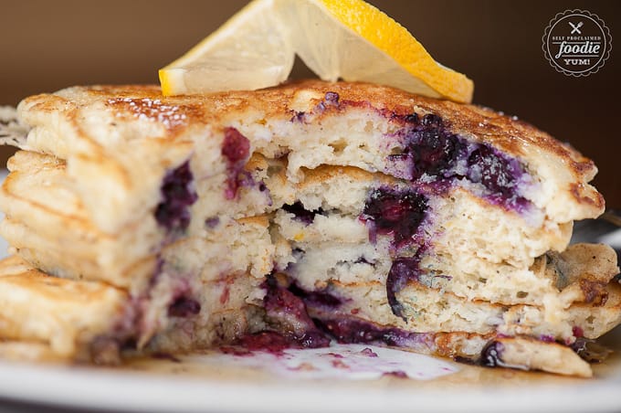 stack of Lemon Blueberry Buttermilk Pancakes with a big bite cut out