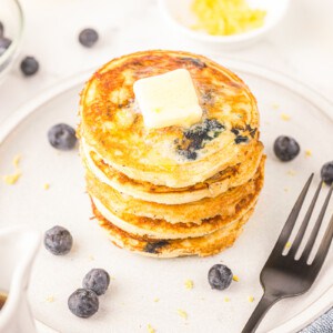 Homemade lemon blueberry pancakes with pad of butter.