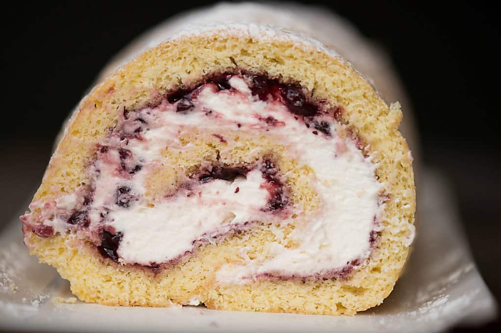 A close up of a lemon lingonberry jam cake roll