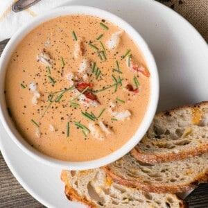 homemade lobster bisque in bowl with bread on side