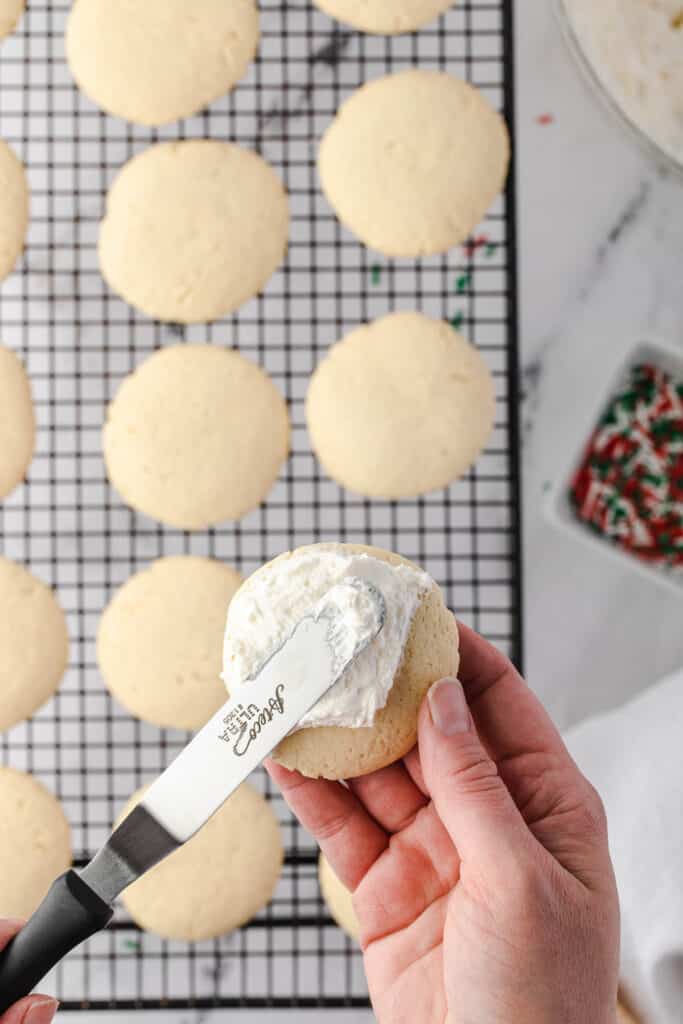 spreading frosting onto soft sugar cookie